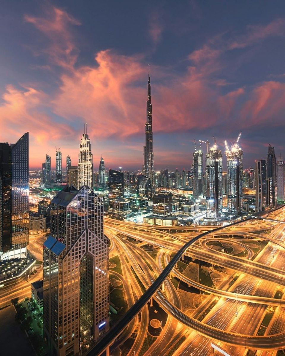 A city skyline lit up at night, viewed from a high vantage point