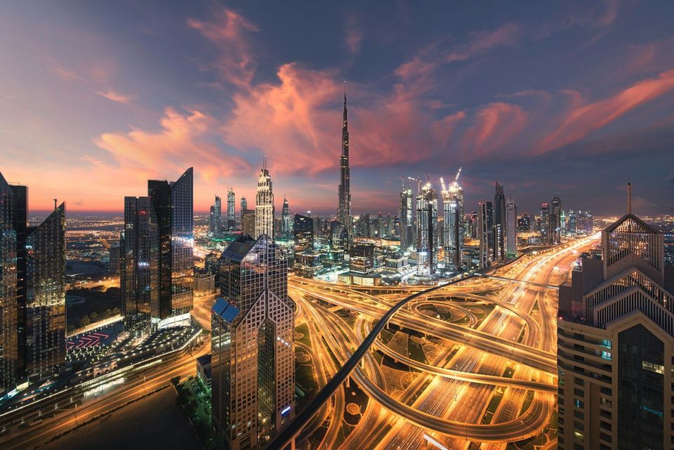 A city skyline lit up at night, viewed from a high vantage point