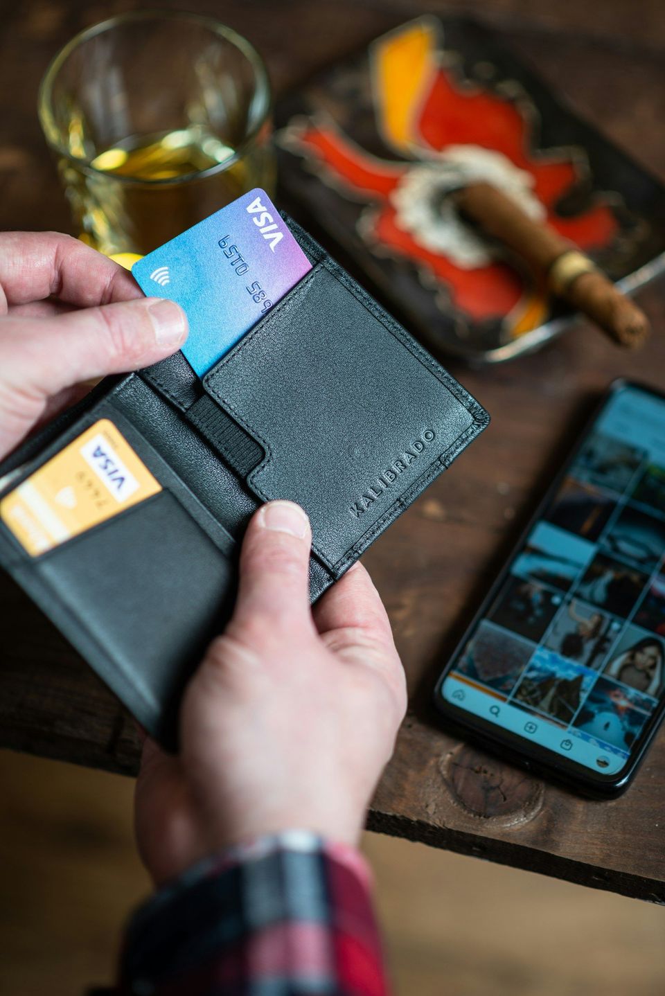 A black leather wallet held in someone's hand